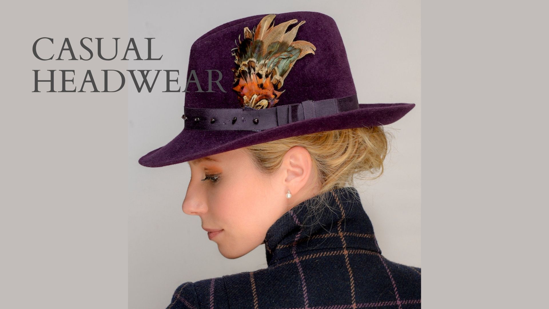 Handmade aubergine fedora finished with a handmade feather corsage 